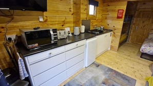 A compact kitchen with a microwave, toaster, and coffee maker on a black countertop. - Rabbit Lodge Dog Friendly nr Anderby Creek (Alford)