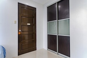 A closed wooden door with a nameplate and a sliding glass door with frosted glass panels. - City Comfort at Seibu Tower (Taguig City)