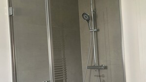 A glass-enclosed shower with a handheld showerhead and a wall-mounted faucet. - Stylish dream apartment - 2 bedrooms - balcony (Bayreuth)