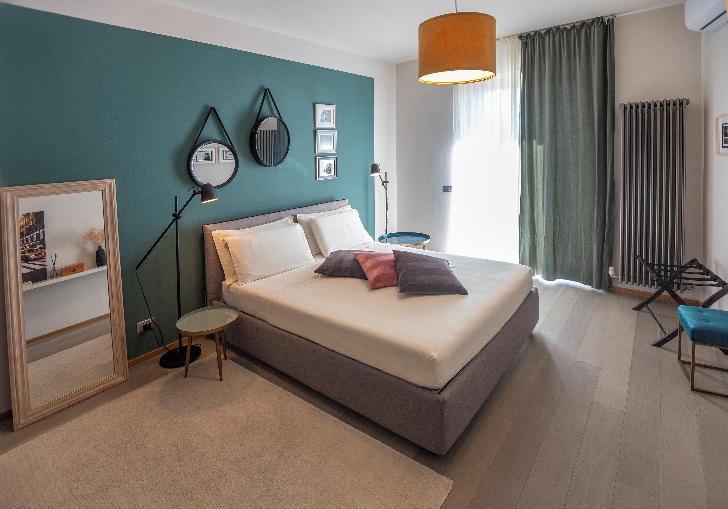 Une chambre à coucher moderne, avec un lit, une lampe de chevet et une vue sur l’extérieur.