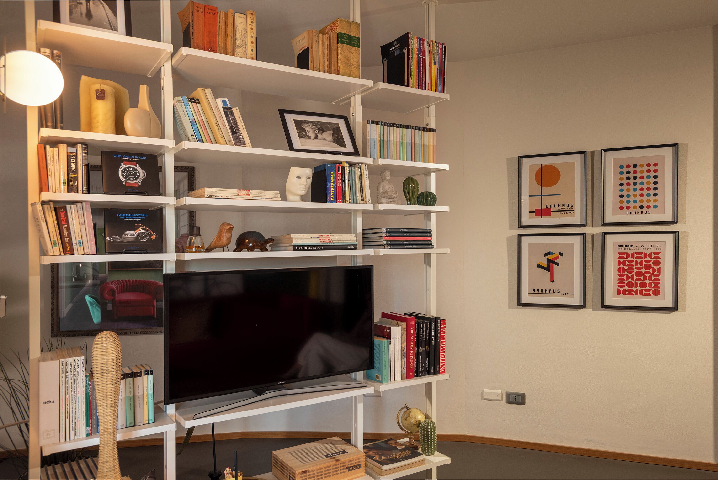 Una sala de estar con televisor de pantalla plana, estanterías y obras de arte enmarcadas.