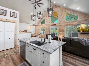 A modern kitchen with a granite countertop, white cabinetry, and a built-in sink. - Spacious 4BR Retreat on 1 Acre | Hot Tub, Pool Table & Near Lake Cascade (Cascade)