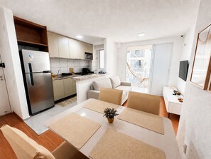 A compact living space with a kitchenette, dining area, and a balcony. - Hosts BR - Apto no Mirante Clube (Fortaleza)