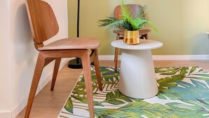 A wooden chair and a small white table with a gold pot and a green plant. - Flatsharing - Gioia Coral suite - 1 bedroom (Milan)