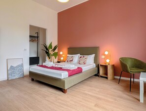 A neatly arranged bedroom with a bed, bedside tables, a chair, and a mirror. - Flatsharing - Gioia Navy suite - 1 bedroom (Milan)