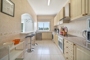 Cuina moderna amb rentaplats, forn i finestra amb vistes.