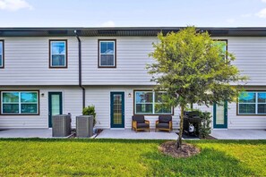 A two-story building with a flat roof, multiple windows, and a small tree in the front yard. - Disney Home w Lake View BBQ Patio & Resort Access (Davenport)
