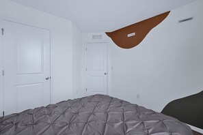 A bedroom with a bed, two white doors, and a brown wall accent. - Disney Home w Lake View BBQ Patio & Resort Access (Davenport)