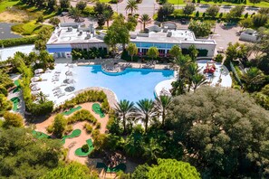 A large swimming pool with a surrounding deck, a golf course, and lush greenery. - Disney Home w Lake View BBQ Patio & Resort Access (Davenport)