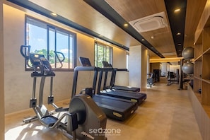 Ein Fitnessstudio mit Laufbändern, Crosstrainern und Trainingsgeräten.