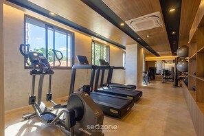 Ein Fitnessstudio mit Laufbändern, Crosstrainern und Trainingsgeräten.