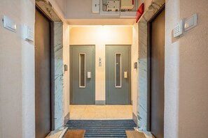 Ein Hotel Eingang mit zwei Türen, einer Sicherheitstastatur und einer Teppichtreppe.
