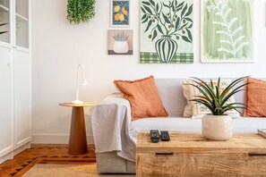Ein Wohnzimmer mit einer Couch, einem Couchtisch, einer Lampe und Kunstwerken an der Wand.