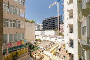 Ein mehrstöckiges Gebäude mit Balkonen, einem Baukran und einem Dachgarten.