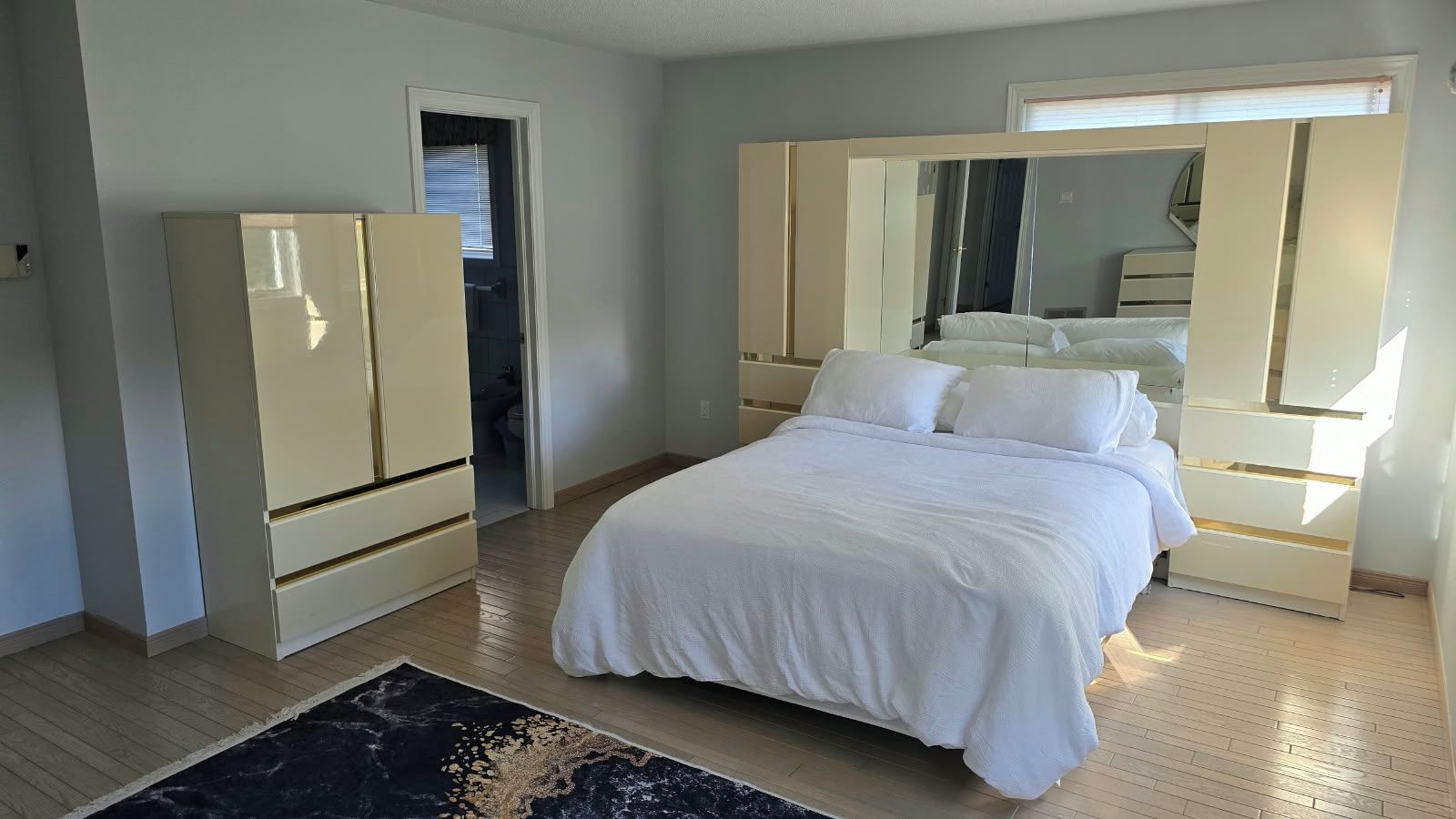 Une chambre à coucher avec un lit, une armoire et un miroir.