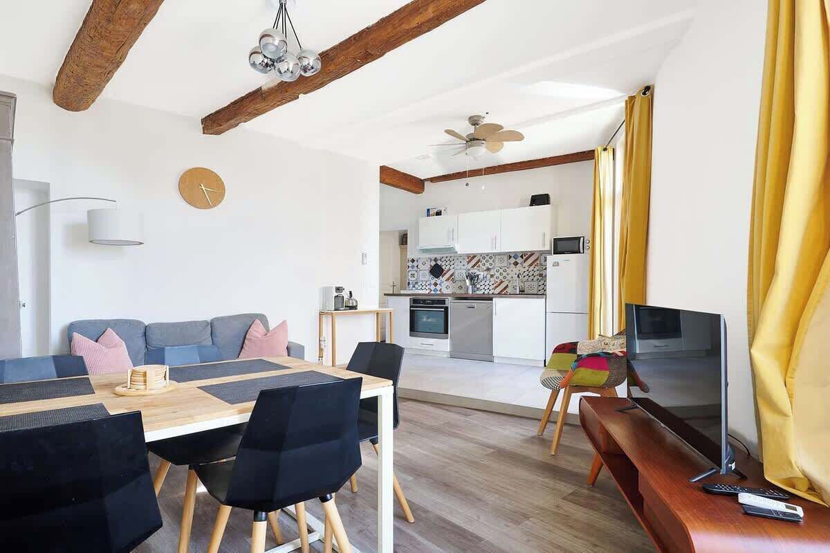Un soggiorno moderno con angolo ristoro, cucina e televisore.