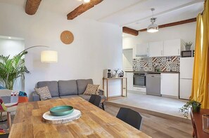 A modern living space with a dining area, kitchen, and a sofa set. - Cozy stay place de la Madeleine (Béziers)