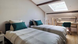 A bedroom with two beds, a skylight, a desk, and a chair. - Designer 70sqm flat with les Halles view, A/C (Béziers)