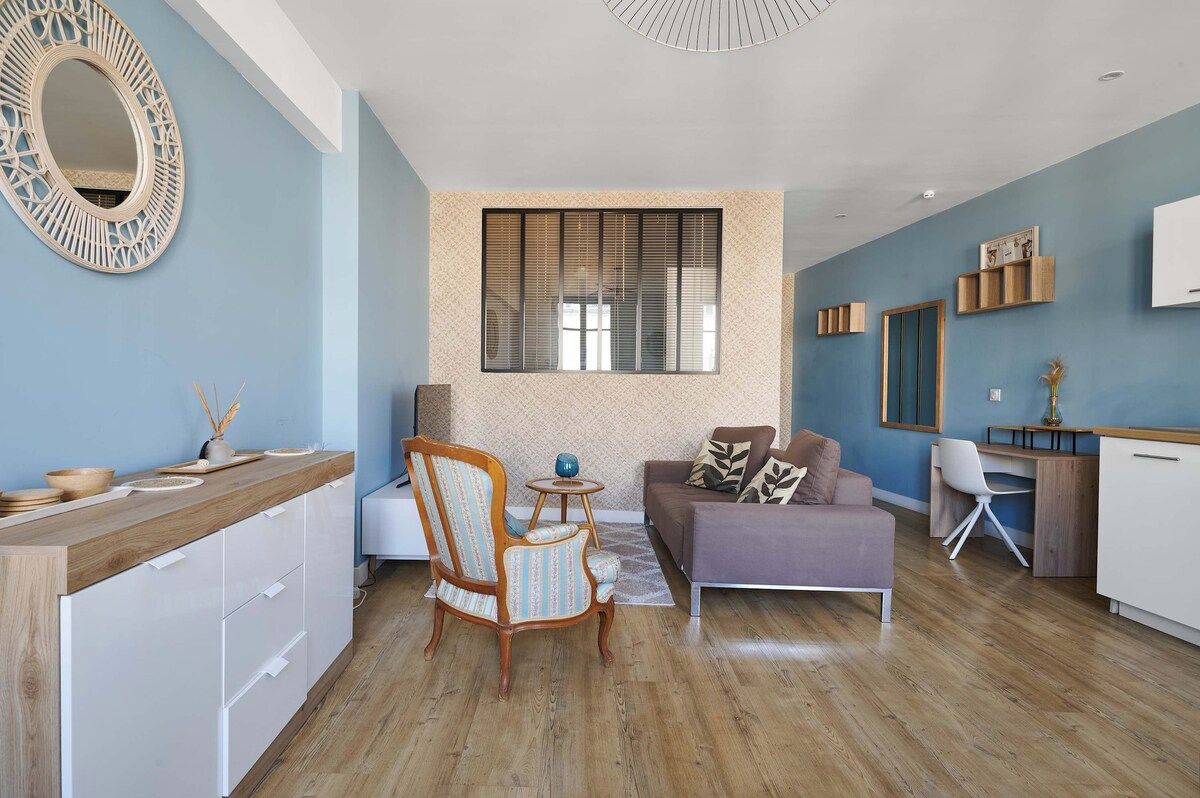 Un espace de vie moderne comprenant une cuisine, un coin repas et un espace détente avec un canapé et des fauteuils.