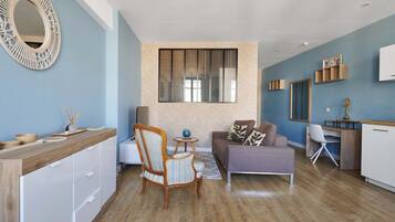 Un espace de vie moderne comprenant une cuisine, un coin repas et un espace détente avec un canapé et des fauteuils.