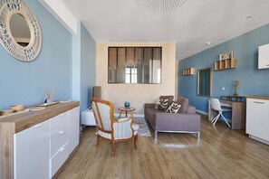 A modern living space with a kitchen, a dining area, and a seating area with a sofa and armchairs. - Elegant flat with Les Halles View & AC (Béziers)