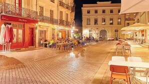 A cobblestone street at night with outdoor seating and buildings on either side. - Studio cosy dominant les Halles avec clim 30m2 (Béziers)