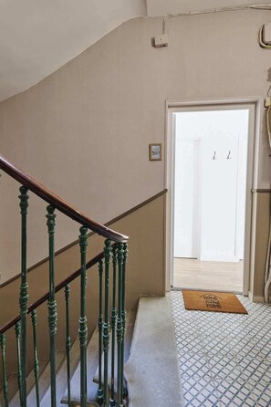 A staircase with green balusters leading to a door with a doormat. - Luxury Stay with view Les Halles, balcony, A/C (Béziers)