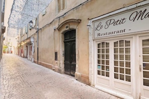 Een straat met cobblestones met een gebouw waarop een bord staat voor 'Le Petit Ma Restaurant'.