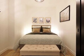 A bedroom with a bed, a bench, and three framed pictures on the wall. - Appartement de prestige au coeur de Beziers (Béziers)