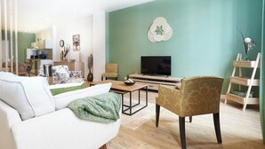 Ein modernes Wohnzimmer mit Sofa, Sesseln, Couchtisch, Fernseher und Dekorationselementen.