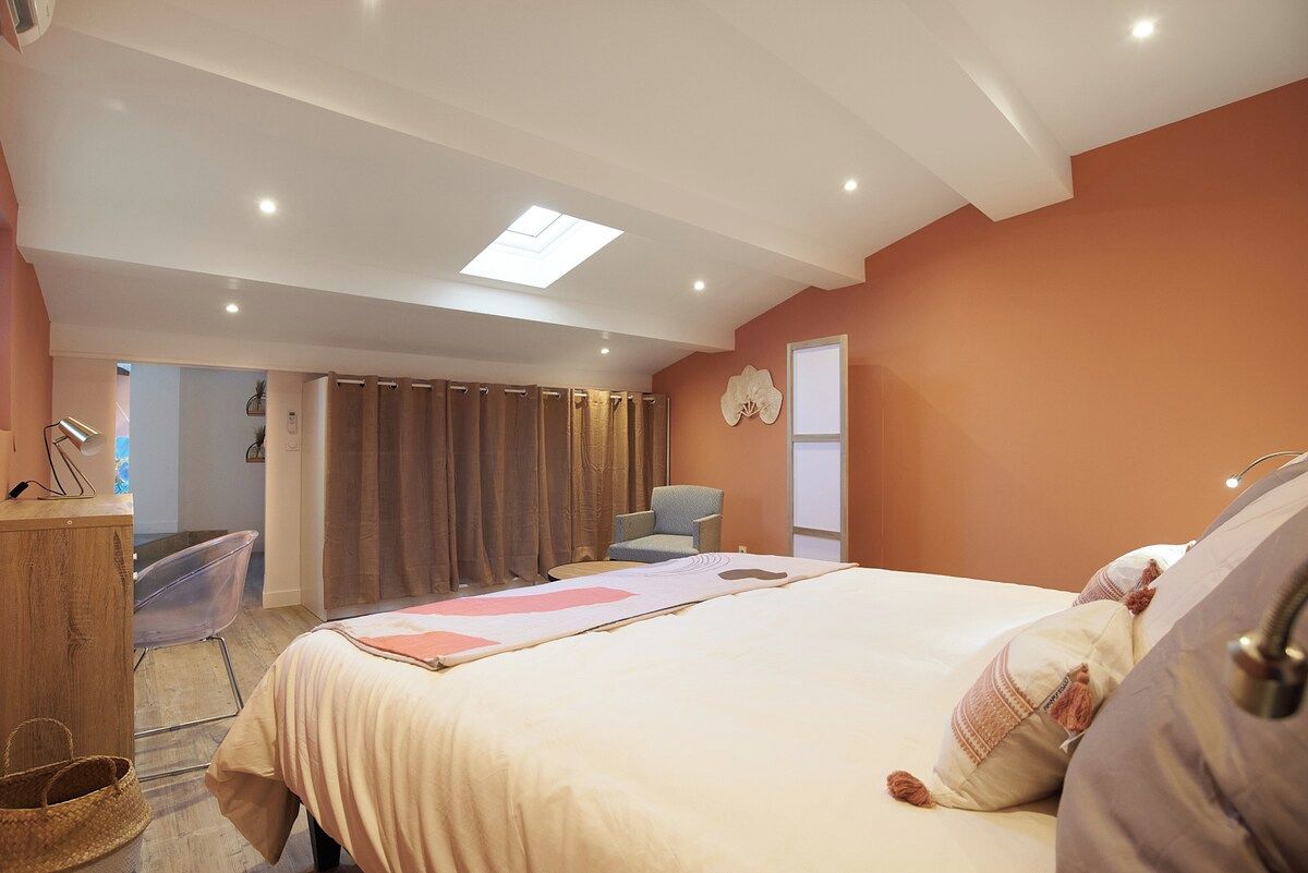 Een slaapkamer met een bed, een bureau, een stoel en een raam.