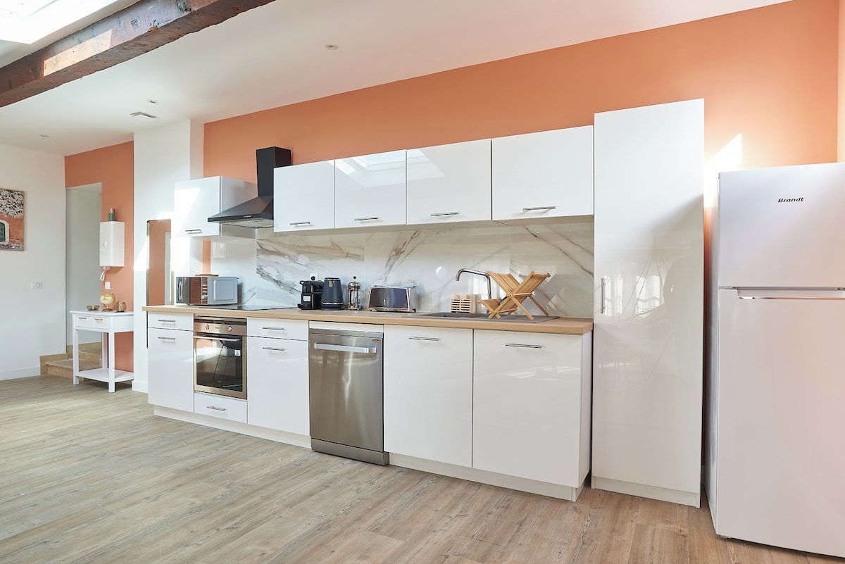 A modern kitchen with white cabinets, a stainless steel dishwasher, and a built-in oven.