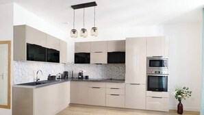 Eine moderne Küche mit Marmorfliesen, Edelstahlgeräten und einem minimalistischen Design.