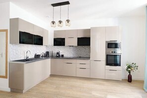 Eine moderne Küche mit Marmorfliesen, Edelstahlgeräten und einem minimalistischen Design.