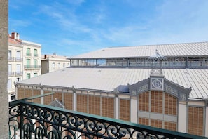 A building with a flat roof, decorative metal railings, and a clear sky. - Le Chic face aux Halles clim  Classe 3 Etoiles (Béziers)