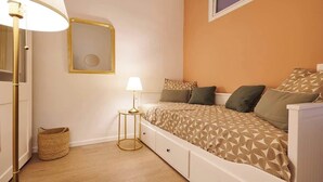 Ein Schlafzimmer mit Bett, Nachttischlampe und einem kleinen runden Tisch.