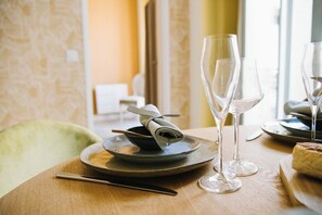 A dining table with a folded napkin, a knife, and two empty wine glasses. - Cozy 1BR with A/C across les Halles (Tourcoing)