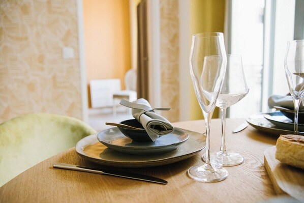 Une table à manger avec une serviette pliée, un couteau et deux verres à vin vides.