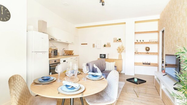 A compact living space with a dining area, kitchenette, and a seating area with a television. - Cozy 1BR with A/C across les Halles (Tourcoing)