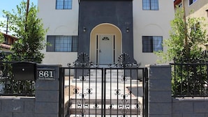 A two-story building with a black and white facade, a central entrance with a white door, and a black wrought iron gate. - 8th & Ardmore  (Los Angeles)