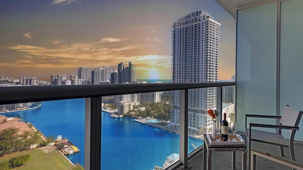 Ein Balkon mit Blick auf eine Skyline und ein Gewässer.