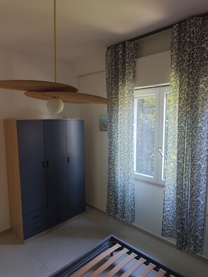 A room with a wardrobe, a ceiling fan, a window with curtains, and a door. - New apartment 100 m from the sea (Montesilvano)