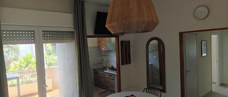 Un comedor con una mesa redonda, sillas y una lámpara colgante.