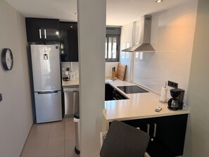 A compact kitchen with a refrigerator, dishwasher, and a coffee maker. - Penthouse Oasis Beach II la Zenia (Orihuela)