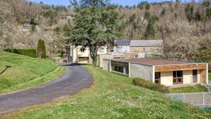 A modern building with a sloped roof, a paved driveway, and a large tree in the foreground. - À 200 m de la plage ! Balcon privé + accès piscine (Miremont)