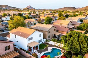 A residential area with houses, a swimming pool, and a mountain in the background. - Sleek 5bed pet friendly & pool (Peoria)