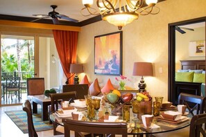 A dining area with a glass table, chairs, and a ceiling fan. There is a view of the outdoors through large windows. - 2BR Suite in beautiful Cancún (Cancún)