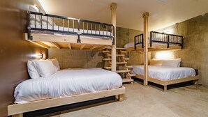 A room with two bunk beds, a wooden staircase, and a concrete wall. - Sleep40 28Beds 10BR Super Stays A12 Low W DD (Louisville)