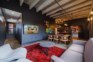 Un intérieur moderne avec un bar, des sièges et des œuvres d’art accrochées aux murs.