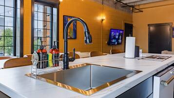 A modern kitchen with a large island, stainless steel appliances, and a built-in sink.